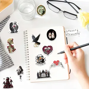 Vista detallada de pegatinas de boda góticas con calaveras y fantasmas en un cuaderno