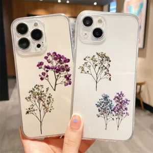 Macro detail of vintage dried baby's breath flower stickers on transparent phone cases.