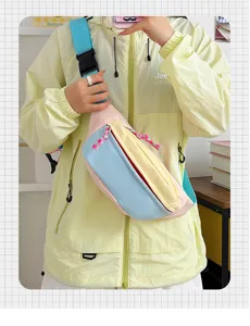 Detailed view of a pastel blue and yellow cute crossbody chest bag worn by a model