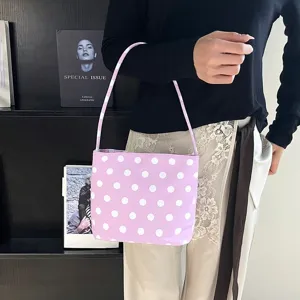 Paarse polkadot schoudertas voor dames in een stijlvolle vrijetijdsomgeving.