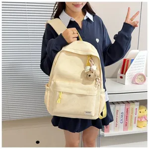 Model met een Japanse crème rugzak met een rimpeltextuur en een schattig beertje