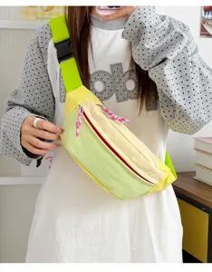 Detail view of a yellow and green lightweight outdoor sports crossbody bag worn by a model