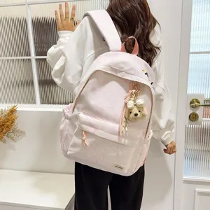 Gedetailleerd overzicht van een student met een roze Japanse getextureerde rugzak met bedel