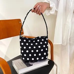 Gedetailleerd overzicht van een stijlvolle zwart-witte polkadot schoudertas