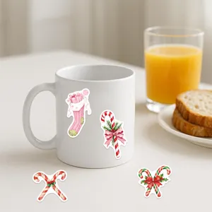Gros plan de stickers de Noël roses sur un mug en céramique blanche dans un cadre chaleureux