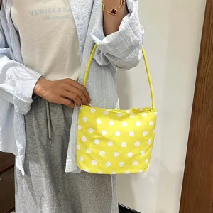 Detail van een gele polkadot onderarmtas gedragen door een model in zomerstijl
