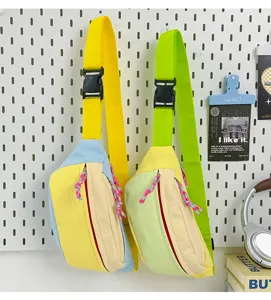 Close-up view of two colorful pastel canvas chest bags hanging on a white pegboard