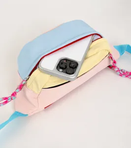 Close-up of front pocket capacity on pastel multi-color chest bag with smartphone