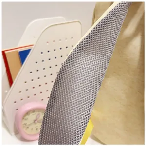 Detailweergave van de ademende mesh-schouderriem van een crèmekleurige rugzak