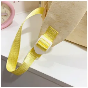 Detailweergave van de gele canvas rugzakband met een verstelbare witte plastic gesp.