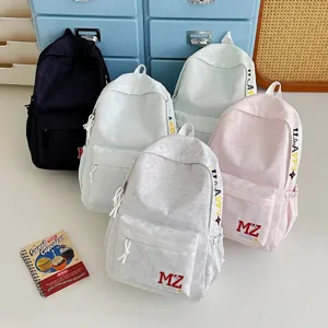 Différentes couleurs de sacs à dos en toile avec des détails brodés 'MZ' et 'HAPPY'
