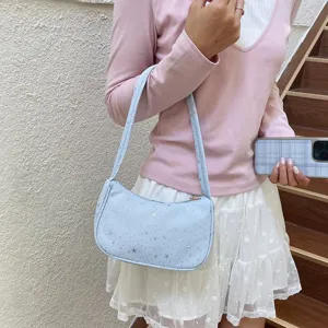 Bolso de hombro azul claro de moda con estrellas plateadas llevado por una modelo