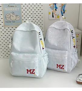 Détail de sacs à dos d'étudiant à motif marbré avec broderie de lettres MZ Lucky.