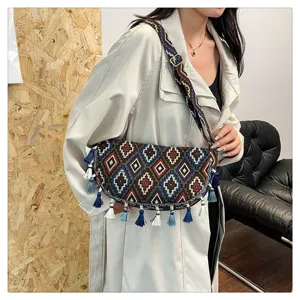 Vintage bohemian crossbodytas met etnisch ruitpatroon en kwastjes op het model.