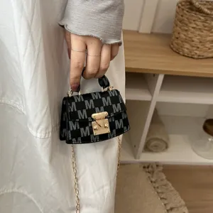 Elegant mini black crossbody bag with white M monogram print and gold chain strap detail