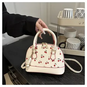 Detailansicht einer modischen weißen Shell-Handtasche mit süßem Kirschmuster-Print