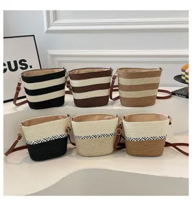 Bolsos tipo cubo de paja tejidos a mano con diversos motivos de rayas y colores naturales.