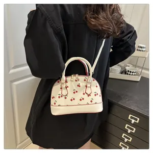 Rückansicht eines Modells mit einer weißen Muschelhandtasche mit rotem Kirschmuster.