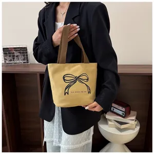 Elegante bolso tote de lona amarilla con estampado de lazo negro y detalles de texto