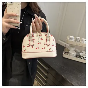 Modische Muschel-Handtasche in Cremeweiß mit Kirschprint und roter Paspelierung