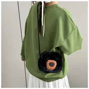 Detailed lifestyle view of a cute black plush bear crossbody bag worn by a model