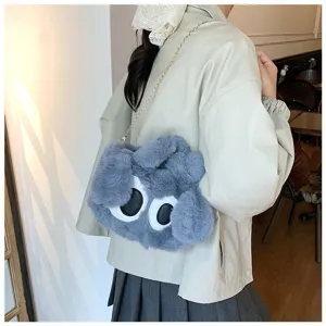 Vista detallada de un bonito bolso bandolera de peluche gris con diseño de ojos grandes