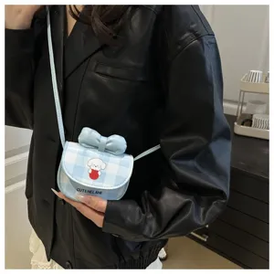 Detalle de un mini bolso bandolera de cuadros azules con perro de dibujos y lazo