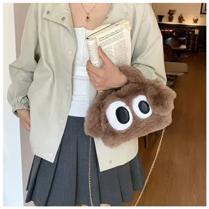 Vista detallada de un bolso de peluche marrón con ojos grandes y cadena de oro elegante