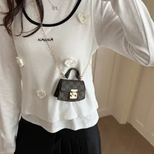 Elegant macro detail of a luxury mini monogram crossbody bag with gold chain strap