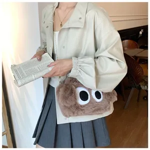 Primer plano de un lindo bolso bandolera de peluche marrón con diseño de ojos grandes
