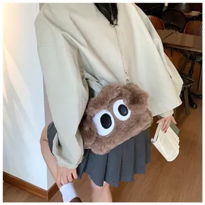 Detalle de un lindo bolso bandolera de peluche marrón con ojos grandes en una modelo