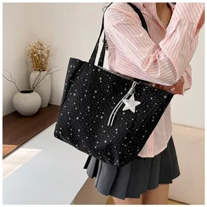 Large black tote bag with white star pattern print and a silver star pendant accessory