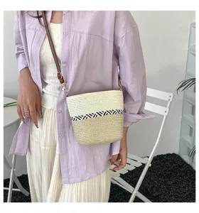 Elegante bolso tipo cubo de paja tejido a mano con rayas en contraste en modelo