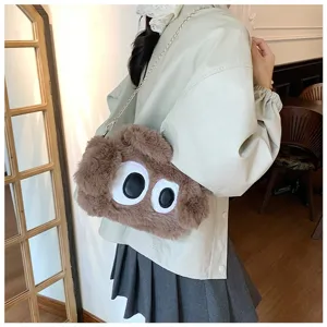 Primer plano detallado del bolso bandolera de peluche marrón con diseño de ojos grandes