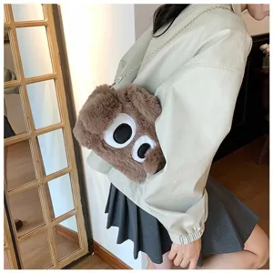 Vista detallada de un lindo bolso de hombro de felpa marrón con diseño de ojos grandes de dibujo