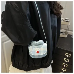 Vista detallada de un mini bolso bandolera de cuadros azules con perro y lazo