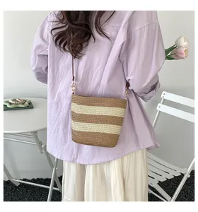 Bolso bombonera de paja tejida a rayas con una camisa informal para las vacaciones