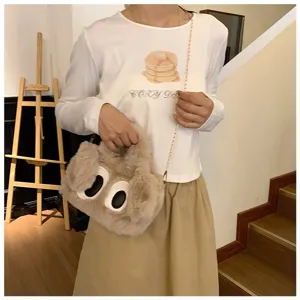 Vista de estilo de vida de un lindo bolso de peluche con ojos grandes y cadena dorada.