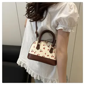 Stilvolle Muscheltasche mit Kirschprint und braunen Details als modische Umhängetasche