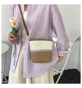 Elegante bolso de paja tejido estilo cubo con patchwork en crema y marrón.