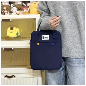 Sacoche d'ordinateur bleu marine tenue à la main avec boutons colorés et poignées