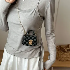 Luxurious mini monogram crossbody bag worn as a stylish accessory with gold chain