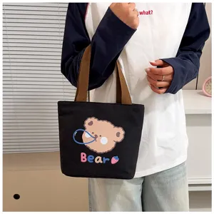 Vista de estilo de vida de un lindo bolso tote de lona negra con diseño de oso