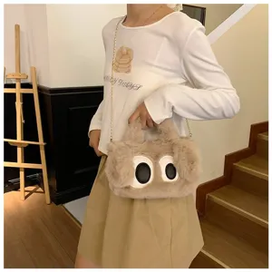 Detalle de un bolso de peluche con ojos grandes de dibujos llevado por una modelo