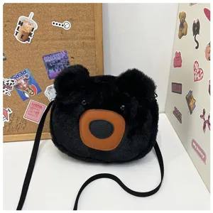 Close-up of cute black plush bear crossbody bag with soft faux fur and brown leather muzzle detail