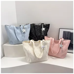 Selection of four star-patterned tote bags in pastel blue black white and pink colors
