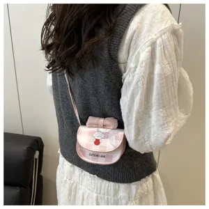 Detalle de mini bolso bandolera a cuadros rosas con perro de dibujos animados y lazo.