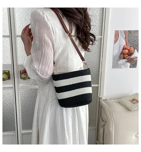 Foto de estilo de vida de una modelo con un bolso de paja a rayas blancas y negras