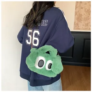 Vista detallada de un bolso bandolera de peluche verde con ojos grandes llevado por una modelo