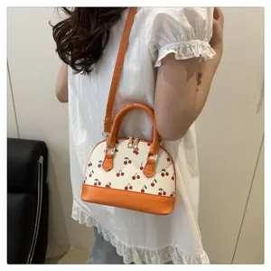 Detailansicht einer stilvollen Kirschdruck-Schultertasche an der Schulter eines Models